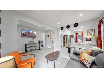 Living room with a modern aesthetic, featuring a comfy couch and large TV at 730 E Alameda Ave, Denver, CO 80209