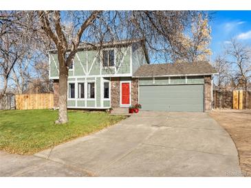 Two-story house with green siding, red front door, and attached garage at 904 S Oakland Ct, Aurora, CO 80012