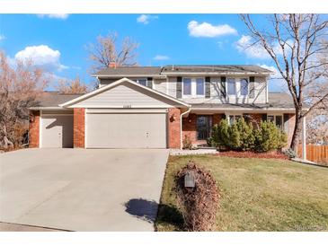 Two-story house with brick and siding, attached two-car garage, and landscaped yard at 11102 Zephyr St, Westminster, CO 80021