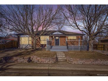 Brick ranch home with a deck and landscaped yard at 1005 Elmer Dr, Northglenn, CO 80233