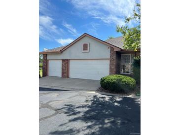 Two-car garage with brick and neutral-colored siding at 15935 E 7Th Ave, Aurora, CO 80011