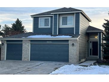 Two-story home with a three-car garage and landscaped front yard at 16272 Willowstone St, Parker, CO 80134