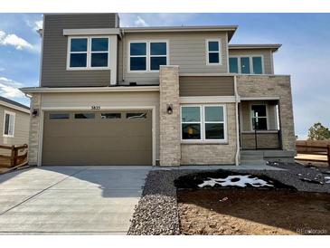 Two-story home with stone and siding accents, a three-car garage, and a landscaped front yard at 3825 N Elk St, Aurora, CO 80019