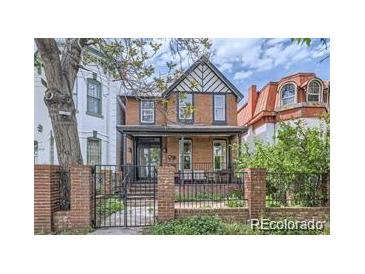 Brick two-story home with a classic design and a gated entryway at 2741 Champa St, Denver, CO 80205