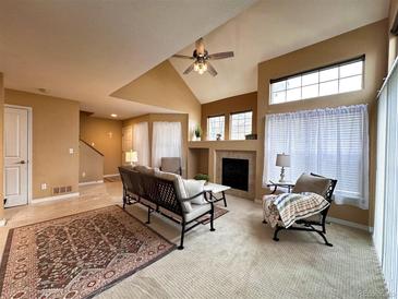 Bright living room with vaulted ceiling, fireplace, and lots of natural light at 13900 Lake Song Ln # B1, Broomfield, CO 80023