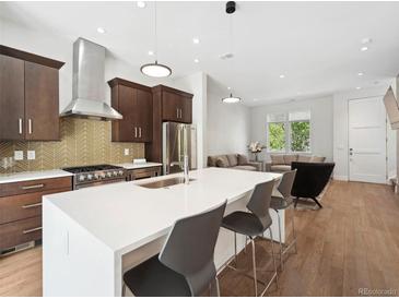 Modern kitchen with island, stainless steel appliances, and hardwood floors at 3100 E 17Th Ave, Denver, CO 80206