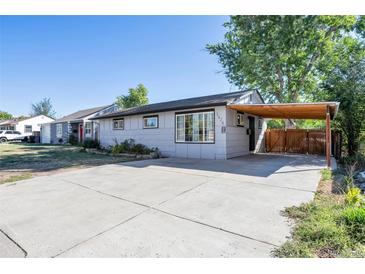Ranch style home with carport, landscaping, and paved driveway at 1626 S Sheridan Blvd, Denver, CO 80232