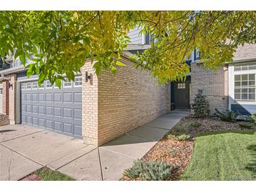 Home's exterior, showcasing a gray garage door and walkway at 9353 Wiltshire Dr, Highlands Ranch, CO 80130