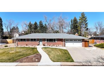 Brick ranch house with attached garage, landscaped lawn, and walkway at 7035 S Gray Ct, Littleton, CO 80128