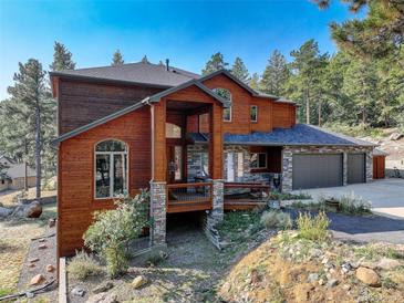 Two-story home, wood siding, stone accents at 7747 S Settlers Dr, Morrison, CO 80465