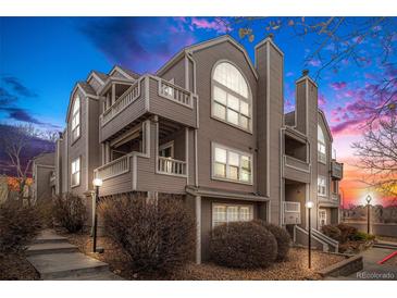 Two-story condo building with neutral exterior and landscaping at 5775 W Atlantic Pl # 303, Lakewood, CO 80227