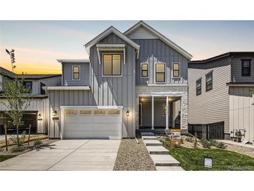 Two-story home with gray siding, white trim, and a covered porch at 11077 Star Fall St, Littleton, CO 80125