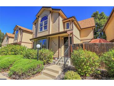 Tan two-story townhome with landscaping and steps at 1736 S Pagosa Way, Aurora, CO 80017
