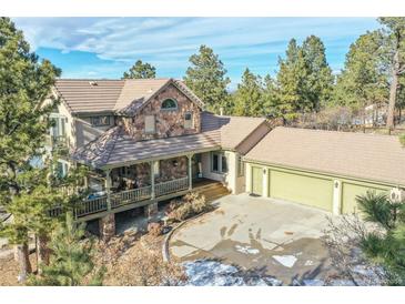 Charming two-story home with stone accents, a covered porch, and a three-car garage at 5519 Ponderosa Dr, Parker, CO 80134