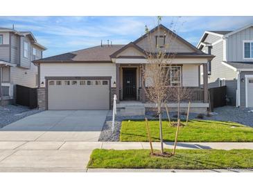 House exterior featuring a two-car garage and well-manicured lawn at 9723 Ceylon St, Commerce City, CO 80022