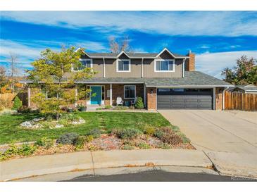 Two-story home with brick and siding, attached garage, and landscaping at 6390 S Quay Ct, Littleton, CO 80123