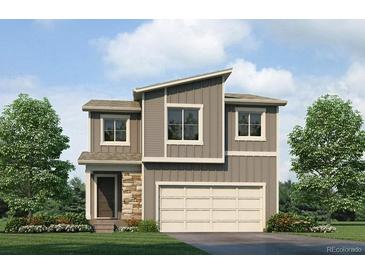 Two-story modern home with gray siding, stone accents, and a two-car garage at 18051 Dandy Brush Ln, Parker, CO 80134