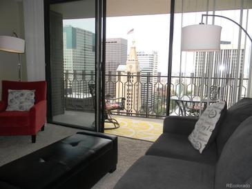 Living room with balcony access showcasing stunning city views at 1020 15Th St # 26I, Denver, CO 80202
