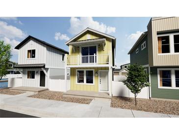 Two-story home with light yellow siding, balcony, and landscaping at , Commerce City, CO 80022