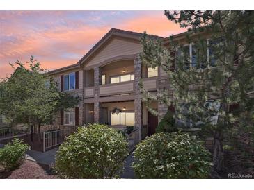 Two-story townhome with stone and siding exterior, balconies, and landscaping at 7160 S Wenatchee Way # F, Aurora, CO 80016