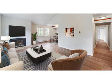 Bright living room featuring a fireplace and access to a dining area at 8100 W Quincy Ave # B12, Littleton, CO 80123