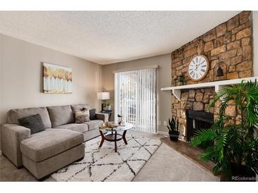 Cozy living room featuring a stone fireplace and comfortable seating at 1926 S Vaughn Way # 101, Aurora, CO 80014