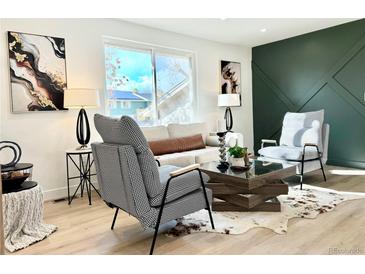 Living room with a green accent wall and modern furniture at 8230 Field Ct, Arvada, CO 80005