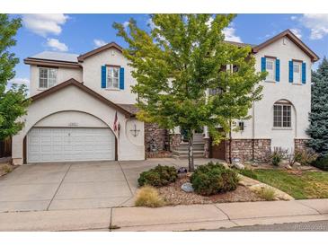 Two-story house with white exterior, blue shutters, and a two-car garage at 2891 Canyon Crest Dr, Highlands Ranch, CO 80126