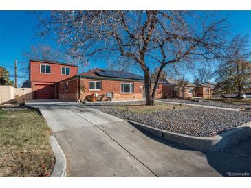 Brick ranch home with solar panels, landscaped yard, and attached garage at 9250 Lillian Ln, Thornton, CO 80229