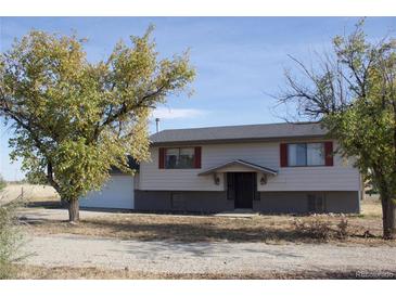 Ranch style home with attached garage and mature trees at 3800 Converse Rd, Bennett, CO 80102