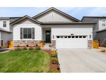 One-story home with white siding, stone accents, and a two-car garage at 3314 Quicksilver Rd, Frederick, CO 80516