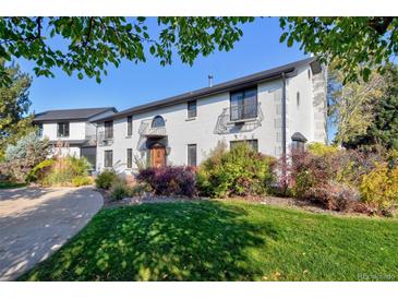 Two-story white brick home with landscaped lawn and driveway at 1490 Saint Andrews Dr, Broomfield, CO 80020