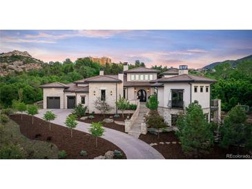 Luxury home with stone exterior, landscaping, and a large driveway at 11164 Beatrice Ct, Littleton, CO 80125