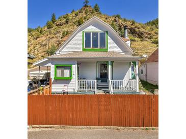 Charming white house with green accents and a hilltop view at 902 Virginia St, Idaho Springs, CO 80452