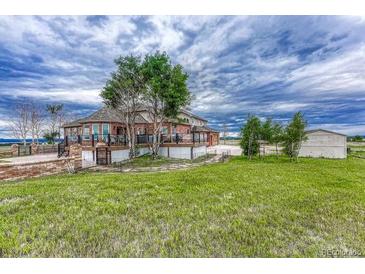 Two-story house with large deck, detached garage, and expansive yard at 1820 S State Highway 83, Franktown, CO 80116
