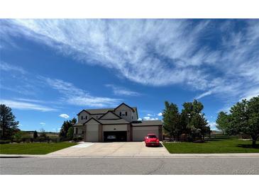 Two-story house with a three-car garage and landscaped yard at 7047 Lionshead Pkwy, Lone Tree, CO 80124