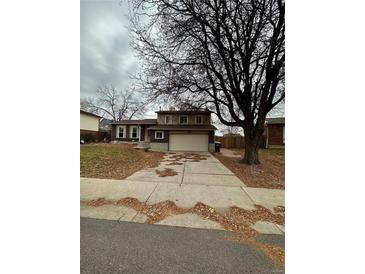 Two-story home with attached garage and mature trees at 7680 S Garland St, Littleton, CO 80128
