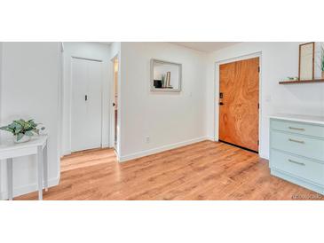 Bright entryway with wood-look floors, coat closet, and access to kitchen at 1150 Golden Cir # 205, Golden, CO 80401