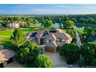 Luxury home with a stunning view of the golf course and lake. Solar panels on the roof at 2421 Ranch Reserve Rdg, Denver, CO 80234