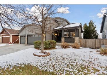 Two-story home with gray siding, attached garage, and landscaping at 5926 W Long Dr, Littleton, CO 80123