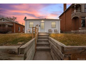 White bungalow home with steps leading to the front door and small front yard at 2229 S Bannock St, Denver, CO 80223