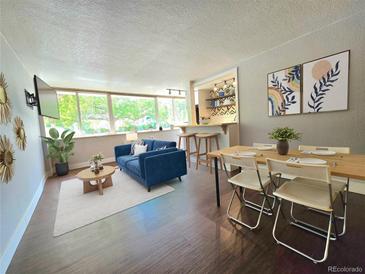 Bright living room with hardwood floors, comfy couch, and a dining area at 1196 N Grant St # 112, Denver, CO 80203