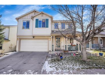 Charming two-story home with a front porch, attached garage, and landscaping at 1214 S Akron Way, Denver, CO 80247
