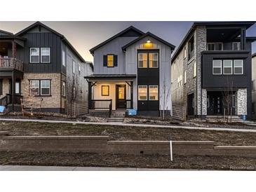 Two-story modern farmhouse exterior, featuring gray siding, black accents, and a front porch at 8665 Middle Fork St, Littleton, CO 80125