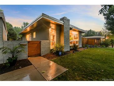 Mid-century modern home with landscaped yard and wooden gate at 6780 S Grant St, Centennial, CO 80122