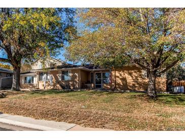 Ranch style home with mature trees and a large front yard at 7465 W 69Th Pl, Arvada, CO 80003