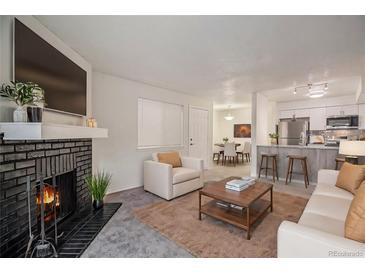 Bright living room with fireplace, open floor plan, and modern furniture at 14704 E 2Nd Ave # E307, Aurora, CO 80011