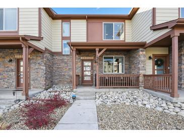 Modern two-story townhome with stone accents and a covered porch at 13741 Via Varra, Broomfield, CO 80020