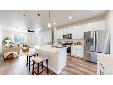 Modern kitchen with white cabinets, stainless steel appliances, and an island at 477 Interlocken Blvd # 103, Broomfield, CO 80021