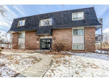 Brick building exterior with walkway and landscaping; winter scene at 309 E Highline Cir # 101, Centennial, CO 80122